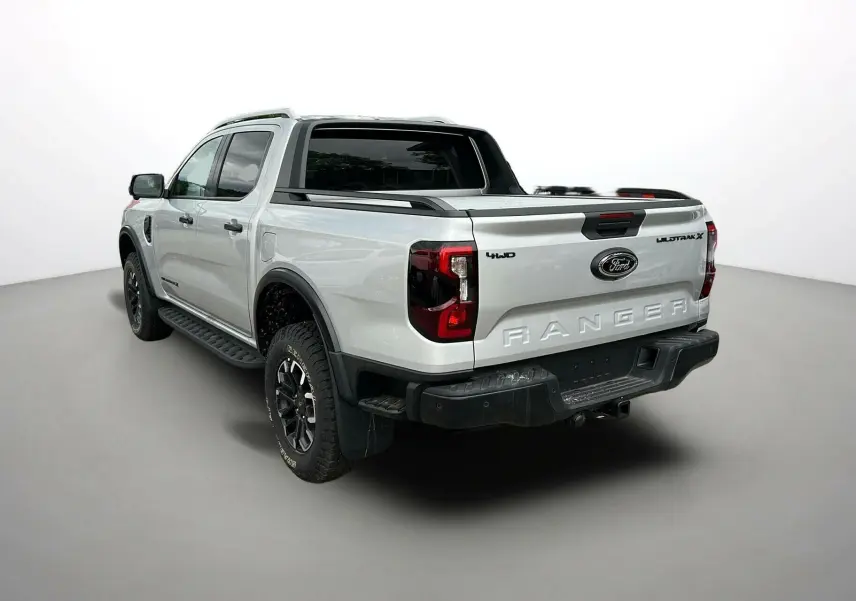Vue 3/4 arrière droite du Ford Ranger 2025 gris iconic avec arceau sport, jantes noires et ridelles de benne.