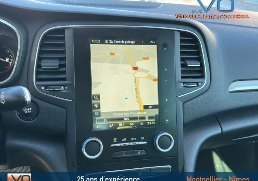 Tableau de bord de Renault Mégane IV beige, vue centrée sur l'écran tactile avec navigation affichée.