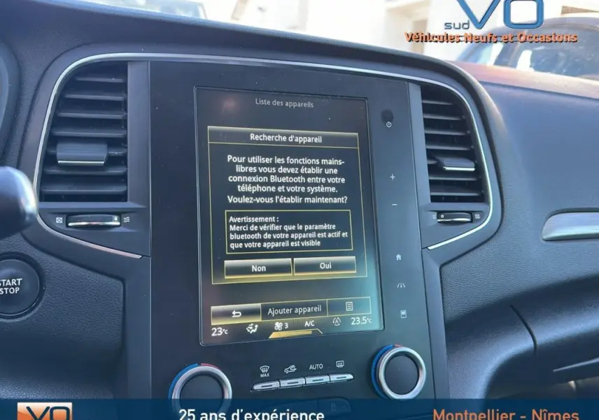 Tableau de bord de Renault Mégane IV beige, vue rapprochée sur l'écran tactile central avec menu Bluetooth affiché.