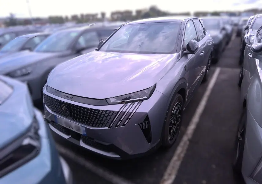 Peugeot 3008 gris vue 3/4 avant droit, mettant en valeur la calandre distinctive et les phares LED fins.