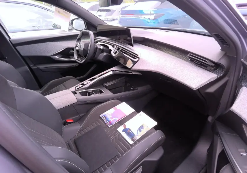 Vue intérieure côté conducteur du Peugeot 3008 gris 2024, avec tableau de bord moderne et écran tactile central.
