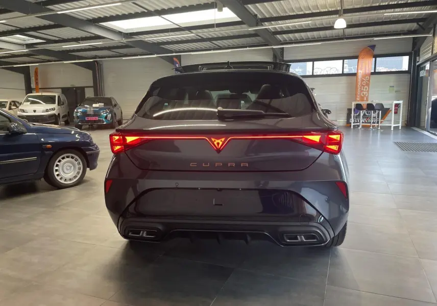 Vue arrière d'une CUPRA Leon gris magnétique avec feux arrière Tri-LED et double sortie d'échappement stylisée.