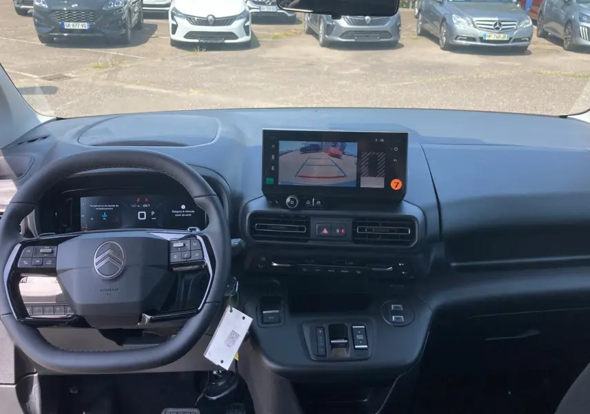 Vue intérieure avant du tableau de bord noir du Citroën Berlingo 2026 avec écran tactile affichant la caméra de recul.
