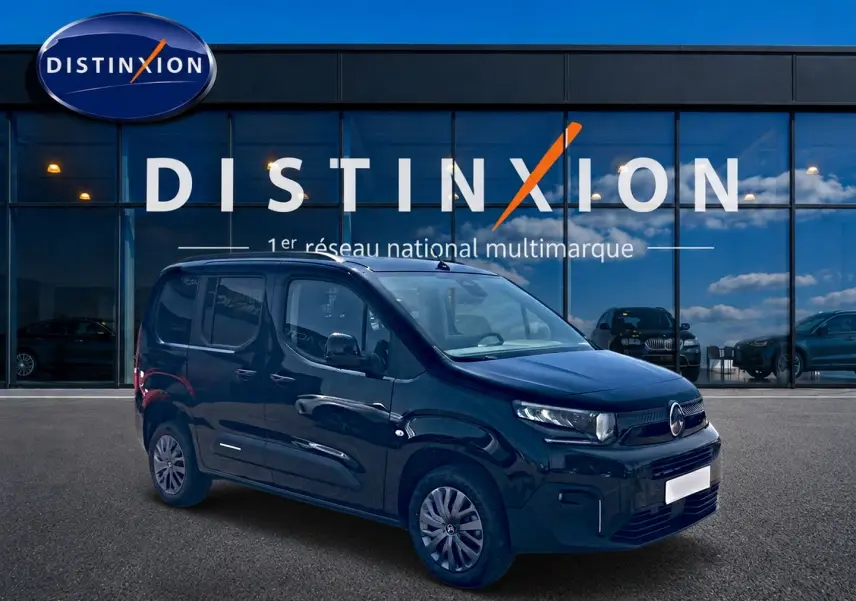 Vue 3/4 avant droite du Citroën Berlingo noir 2026, avec jantes alu et porte latérale visible devant un showroom Distinxion.