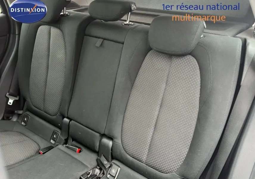 Vue intérieure sur les sièges arrière en tissu gris noir du BMW X1 18i 2018, avec appuie-têtes et ceintures visibles.