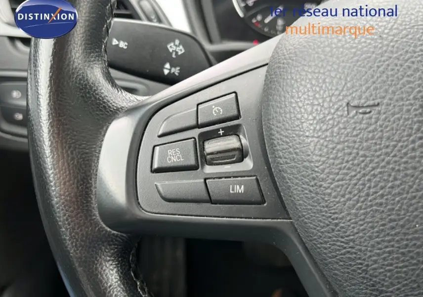 Gros plan sur le volant côté gauche d'une BMW X1 gris argent 2018, avec commandes de régulateur de vitesse.