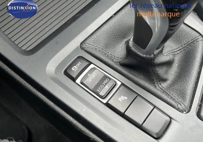 Gros plan sur la console centrale de la BMW X1 18i 2018, montrant le levier de vitesses et les boutons de modes de conduite.