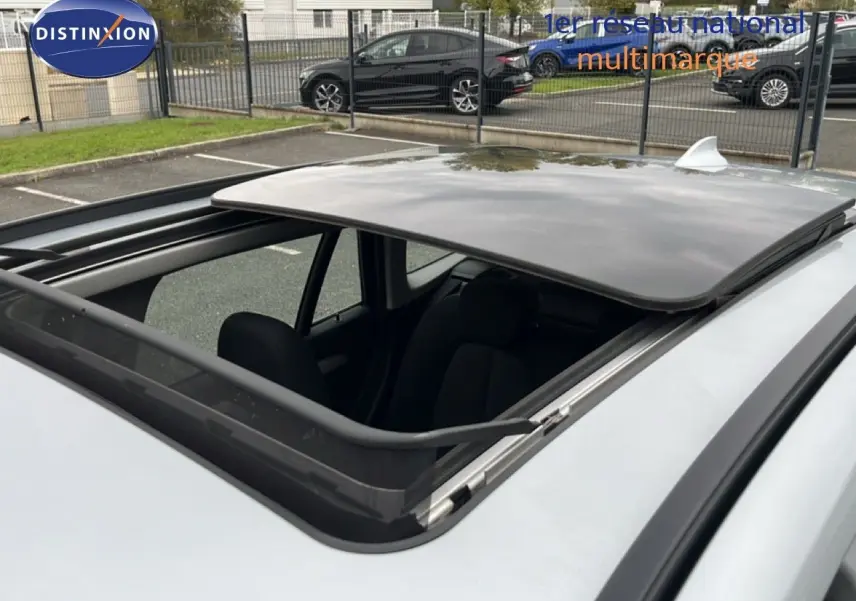 Toit ouvrant panoramique ouvert sur BMW X1 gris argent métal, vue rapprochée depuis le dessus côté gauche.