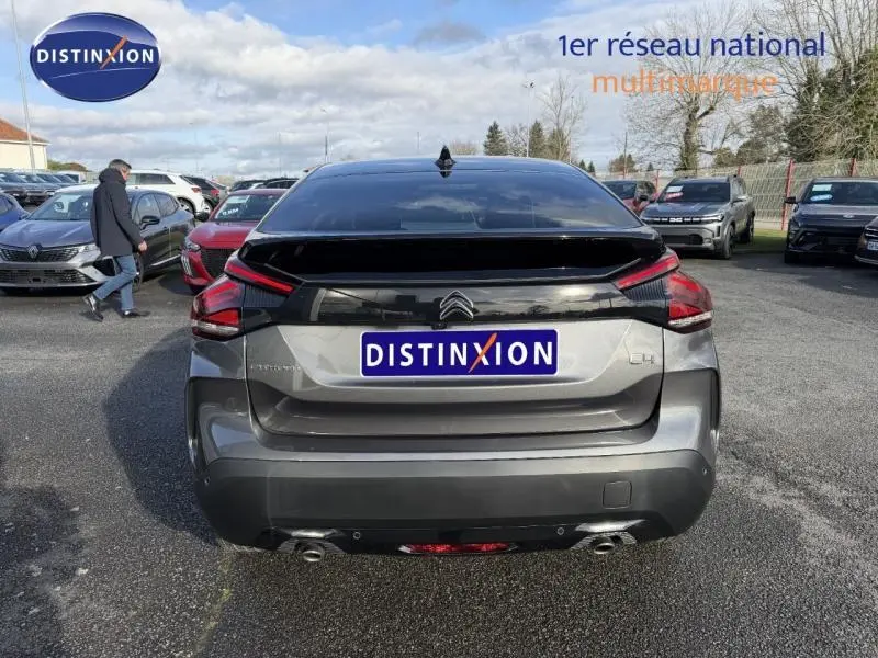 Vue arrière d'une Citroën C4 gris 2024 avec feux arrière LED et double sortie d'échappement visible en extérieur.
