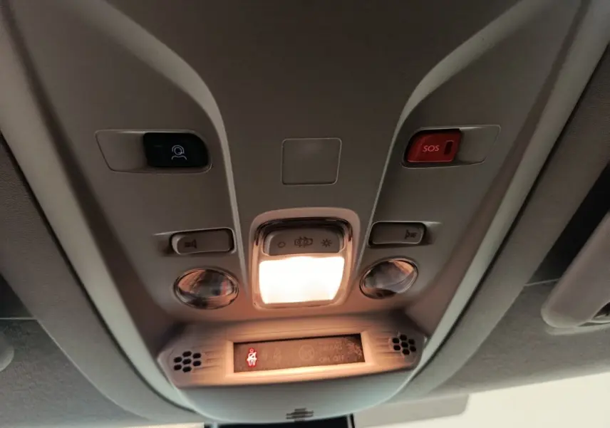Plafonnier intérieur avec éclairage central allumé et boutons SOS et assistance dans un Peugeot Partner blanc 2026.