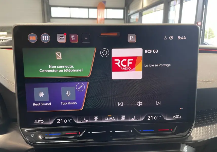 Écran tactile HD 12,9'' du tableau de bord de la CUPRA Leon 2026, affichant la radio RCF, intérieur noir avec surpiqûres cuivrées.
