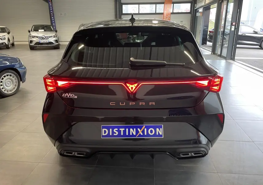 Vue arrière d'une CUPRA Leon noire avec feux arrière en bandeau lumineux et double sortie d'échappement stylisée.