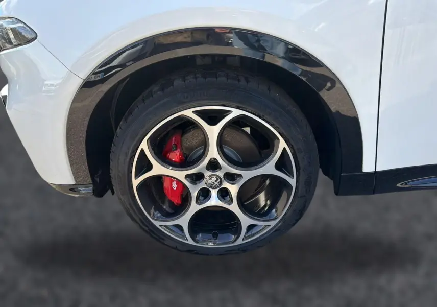 Gros plan sur la roue avant gauche blanche d'Alfa Romeo Tonale 2025 avec étrier de frein rouge et jante alu distinctive.
