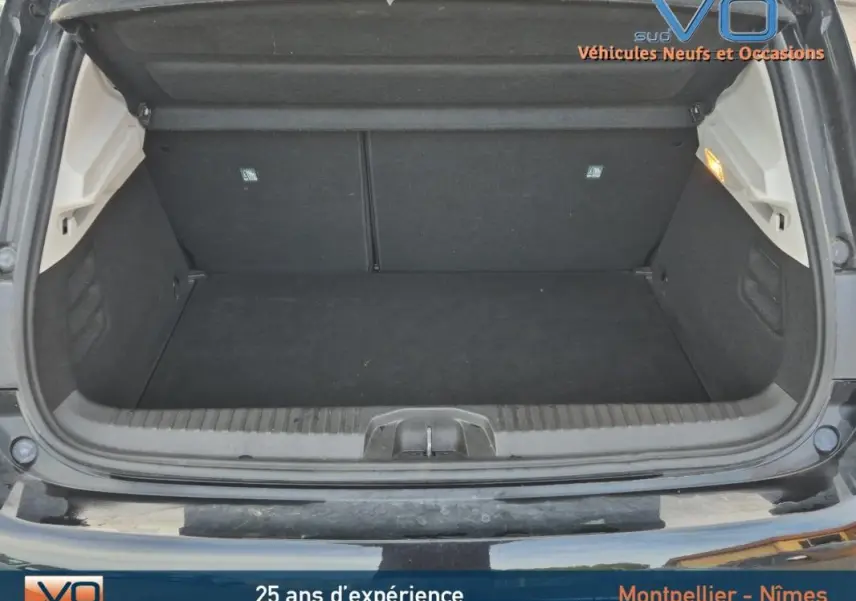 Coffre ouvert d'une Renault Clio V TCe 90 Equilibre noire de 2023, montrant un espace de chargement propre et spacieux.