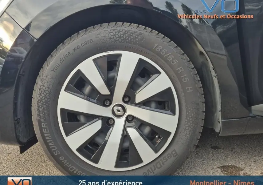 Gros plan sur la roue avant droite de la Renault Clio noire 2023 avec jante alliage distinctive et pneu été.