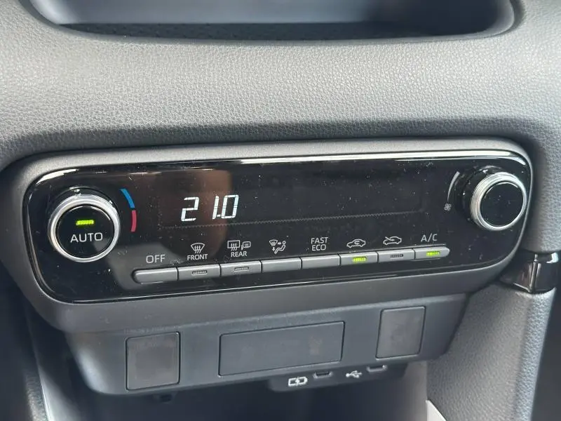 Panneau de commande de climatisation numérique de la Toyota Yaris 116h Dynamic 5p MC24, affichant 21°C en mode automatique.