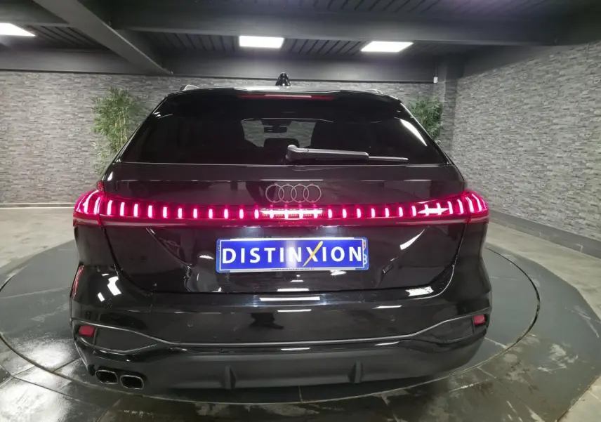 Vue arrière d'une Audi A5 Avant noire 2025 avec feux arrière LED continus et double sortie d'échappement chromée.