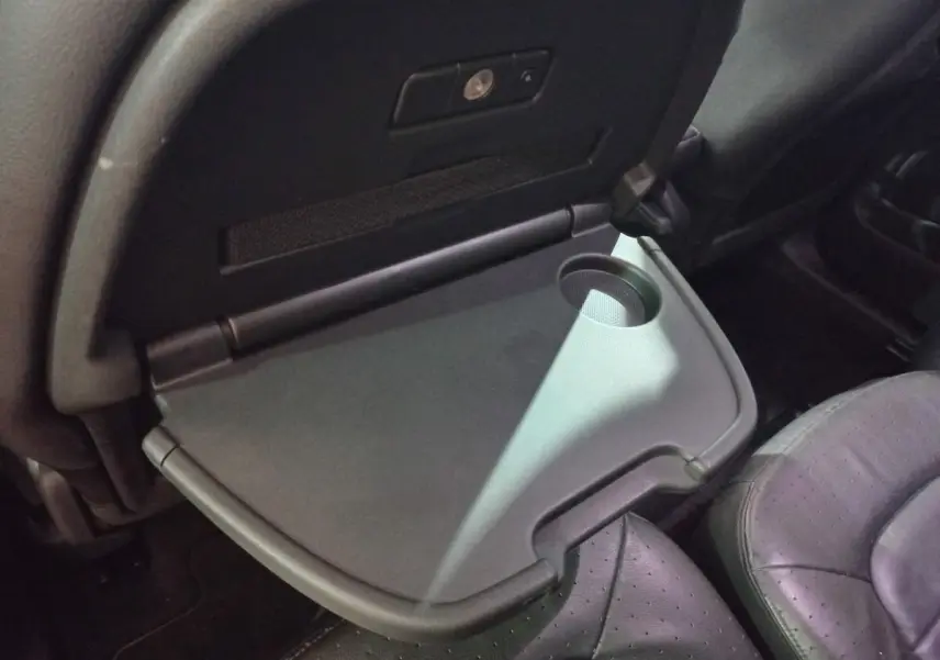 Gros plan sur tablette rabattable avec porte-gobelet côté passager arrière du Citroën Grand C4 Spacetourer noir.