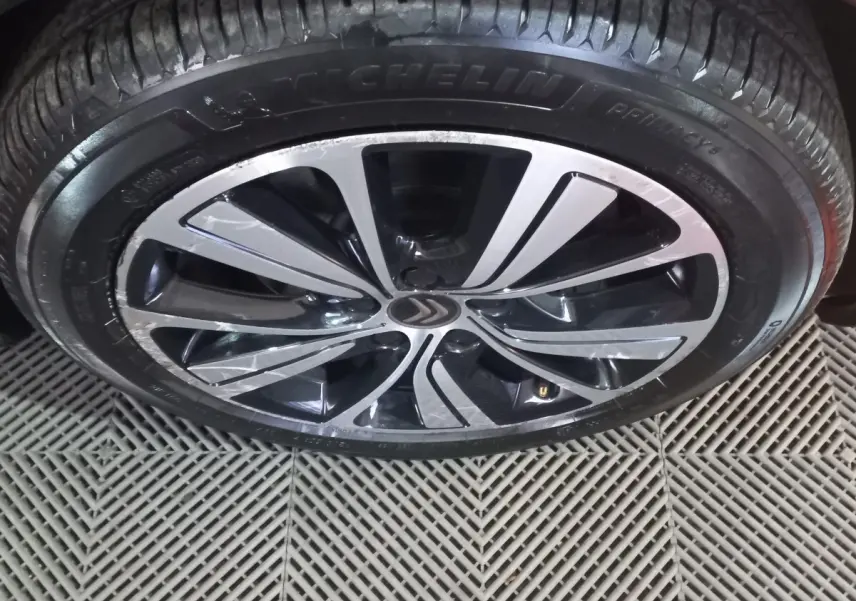 Gros plan sur la jante alliage noire et argentée d’un Citroën Grand C4 Spacetourer noir, pneu Michelin visible.