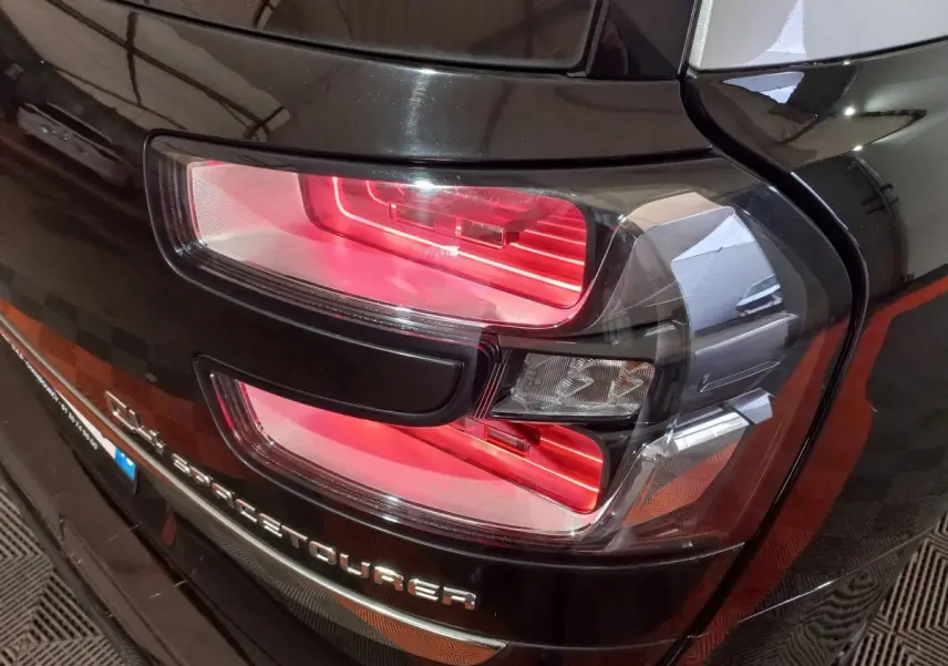 Gros plan sur le feu arrière droit rouge du Citroën Grand C4 SpaceTourer noir, avec logo visible sur le hayon.
