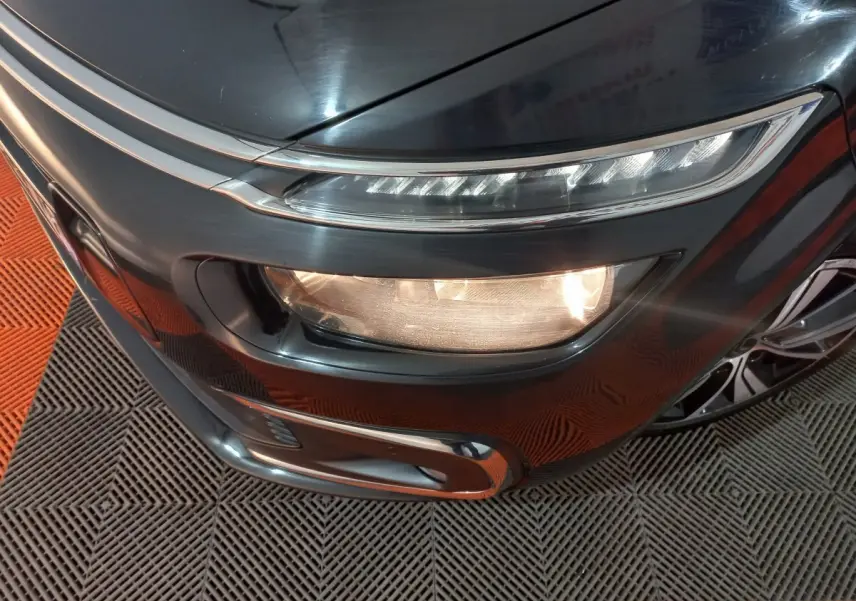 Gros plan sur l'avant droit noir du Citroën Grand C4 Spacetourer avec phares allumés et jante visible.