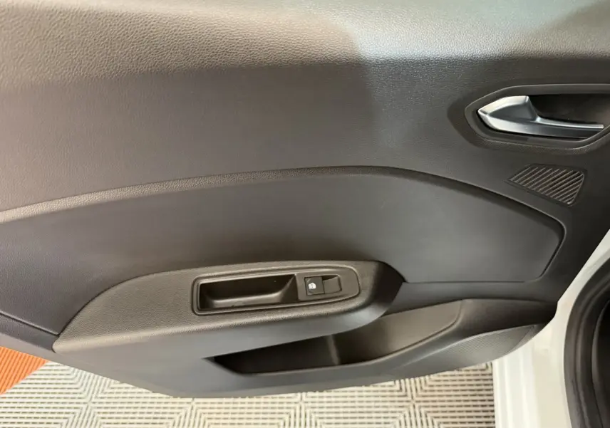 Vue intérieure de la porte avant droite noire d'une Renault Clio Business TCe 100 GPL blanche, avec poignée et commande de verrouillage.