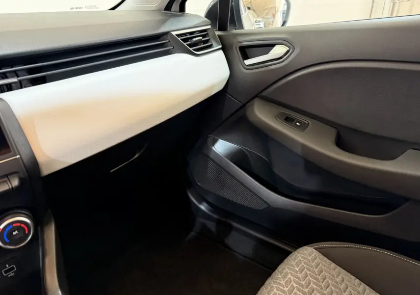 Vue intérieure côté passager de la Renault Clio Business TCe 100 GPL 2022, tableau de bord blanc et porte noire.