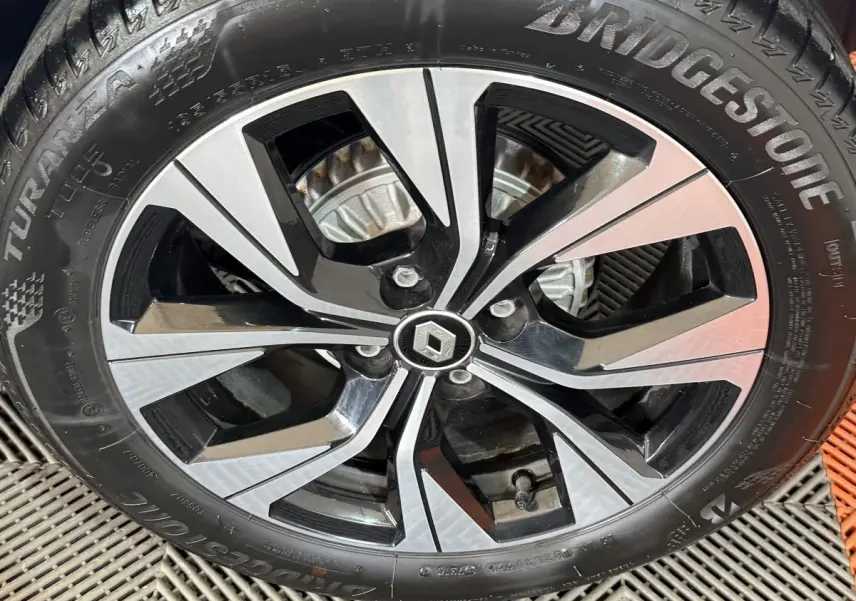 Gros plan sur la jante alliage bicolore noire et argent avec logo Renault au centre sur pneu Bridgestone.