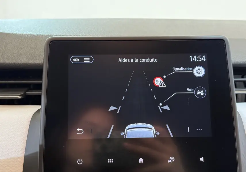 Écran tactile intérieur de la Renault Clio Business blanc, affichant les aides à la conduite et la signalisation.