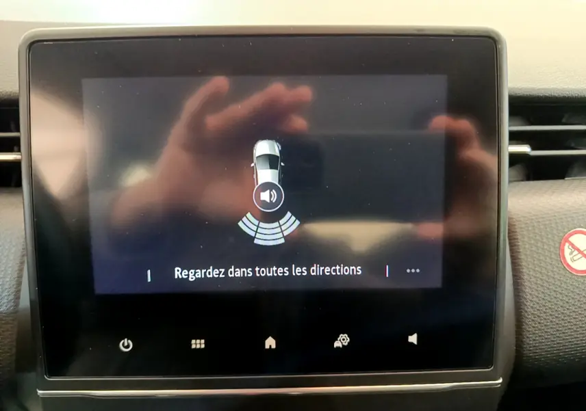 Écran tactile central de la Renault Clio Business blanc 2021 montrant l'alerte de capteurs de stationnement arrière.