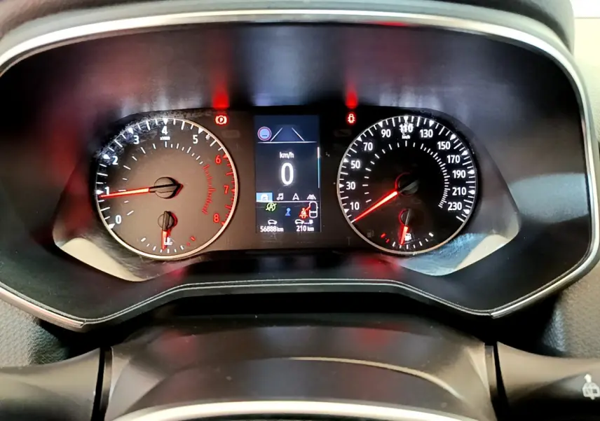 Tableau de bord de Renault Clio Business blanc 2021, affichage numérique central et compteurs analogiques éclairés.