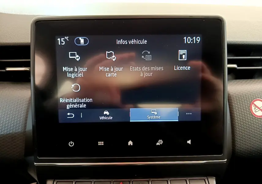 Écran tactile central du tableau de bord de la Renault Clio Business blanc, affichant les options de mise à jour système.