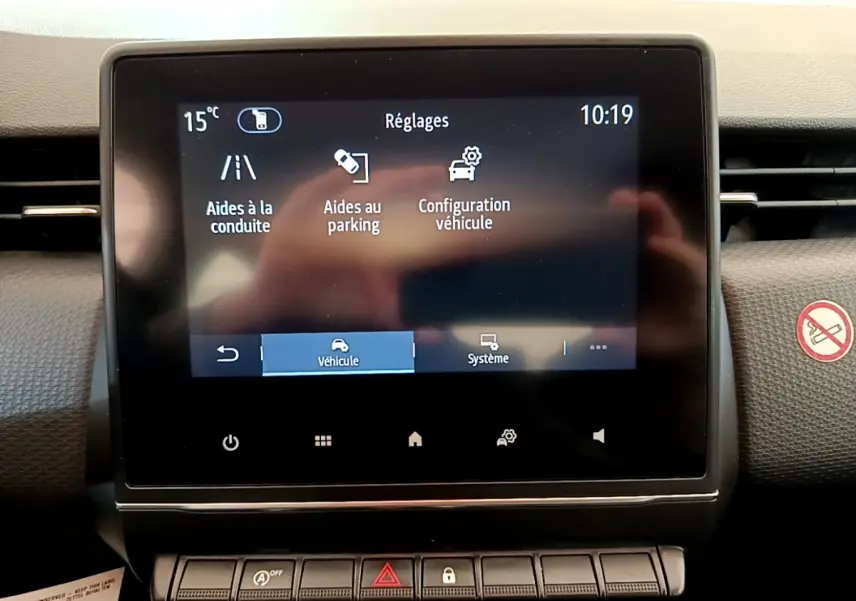 Écran tactile central de la Renault Clio Business blanc 2021 affichant les réglages d’aides à la conduite et parking.