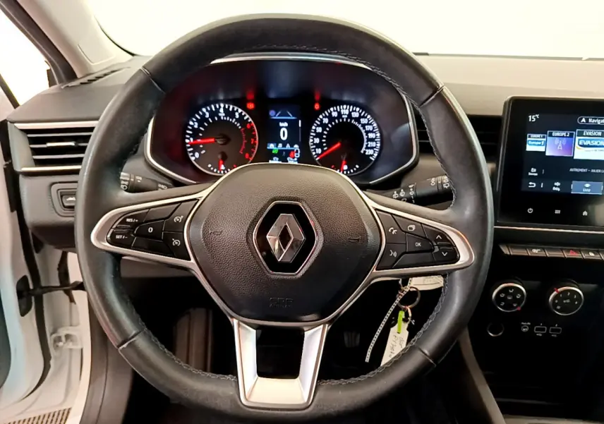 Vue centrée sur le volant cuir noir de la Renault Clio Business blanche, avec tableau de bord et écran tactile visible à droite.