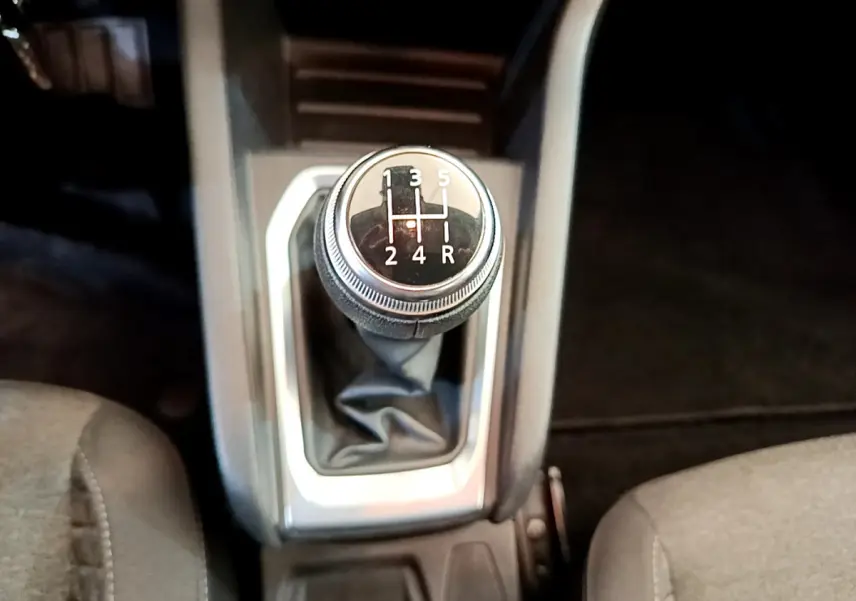 Le levier de vitesses manuel noir de la Renault Clio Business blanc, vu de dessus entre les sièges avant.