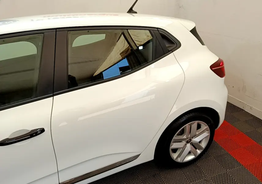 Vue côté droit arrière d'une Renault Clio Business blanche avec jante alliage et poignées noires.