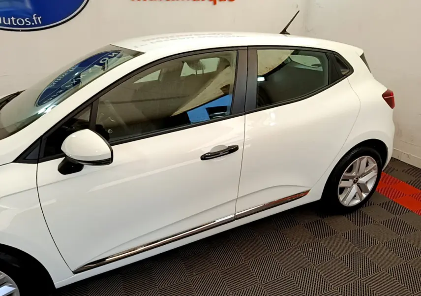 Profil droit de la Renault Clio Business blanche de 2021, avec poignées noires et jantes alliage visibles.