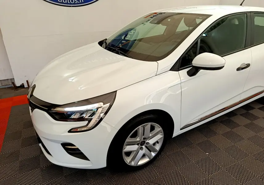 Renault Clio Business blanc vue 3/4 avant droit, phares LED et jantes alliage visibles sur sol damier.