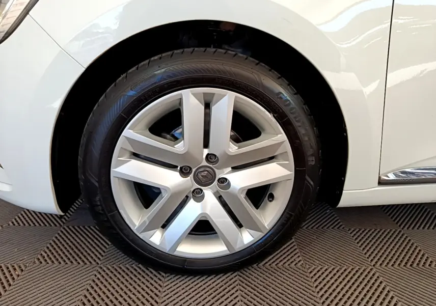 Vue rapprochée de la roue arrière côté gauche d'une Renault Clio Business blanche avec jante visible et carrosserie brillante.