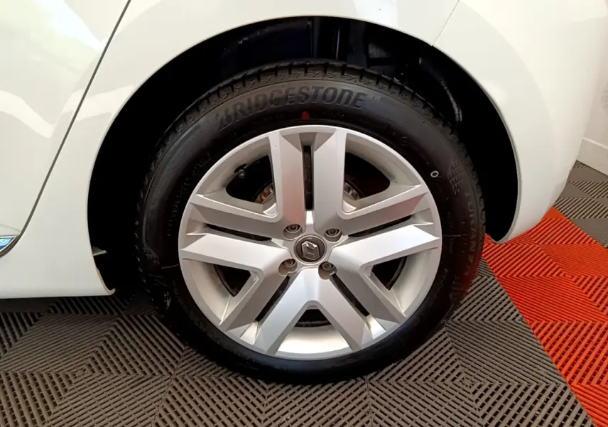 Gros plan sur la roue arrière droite d'une Renault Clio Business blanche, avec partie de la carrosserie visible.