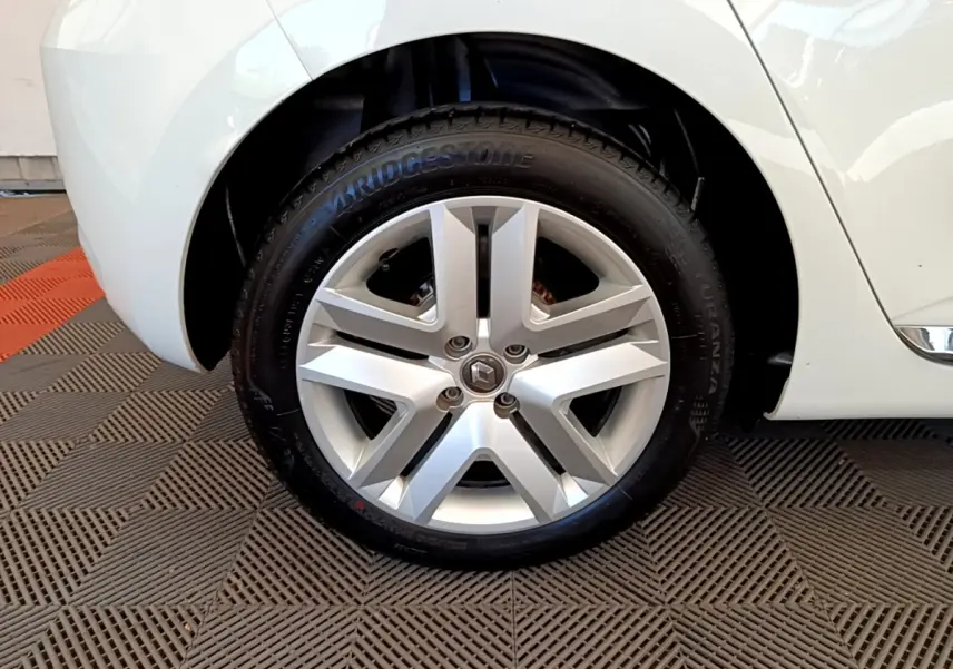 Gros plan sur la roue avant droite d'une Renault Clio Business blanche, avec jante alliage et pneu Bridgestone.