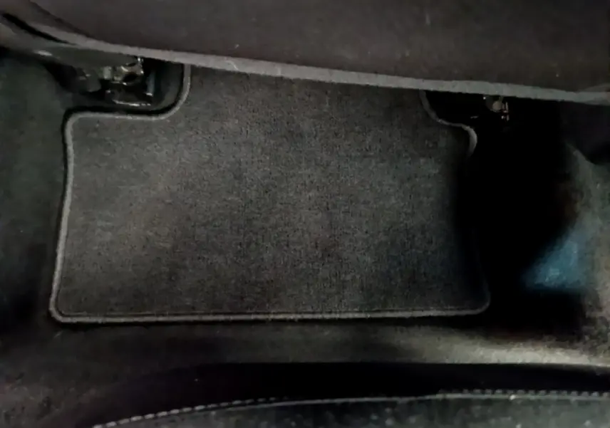 Tapis de sol noir côté conducteur dans une Renault Clio Business blanche vue de l'intérieur au sol.