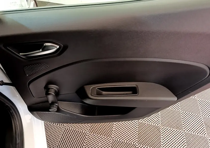 Vue rapprochée de la porte avant gauche noire d'une Renault Clio Business blanche avec poignée et manivelle de vitre.