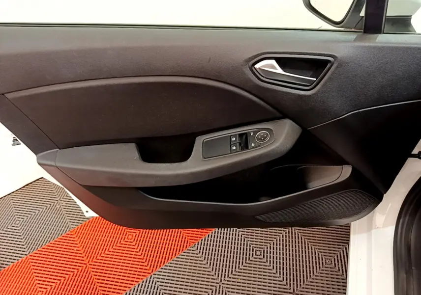 Vue rapprochée de la porte côté conducteur noire de la Renault Clio Business blanche, avec commandes électriques des vitres visibles.