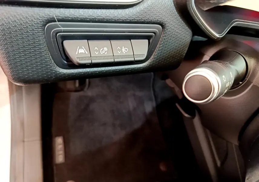Détail des commandes d'assistance au conducteur sur le tableau de bord côté gauche d'une Renault Clio Business blanche 2021.