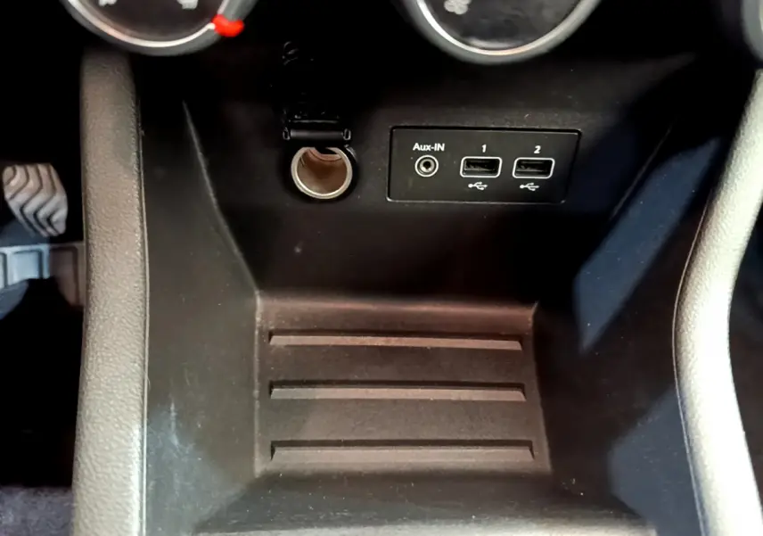Vue rapprochée de la console centrale noire de la Renault Clio Business SCe 65 avec prises USB et prise auxiliaire.