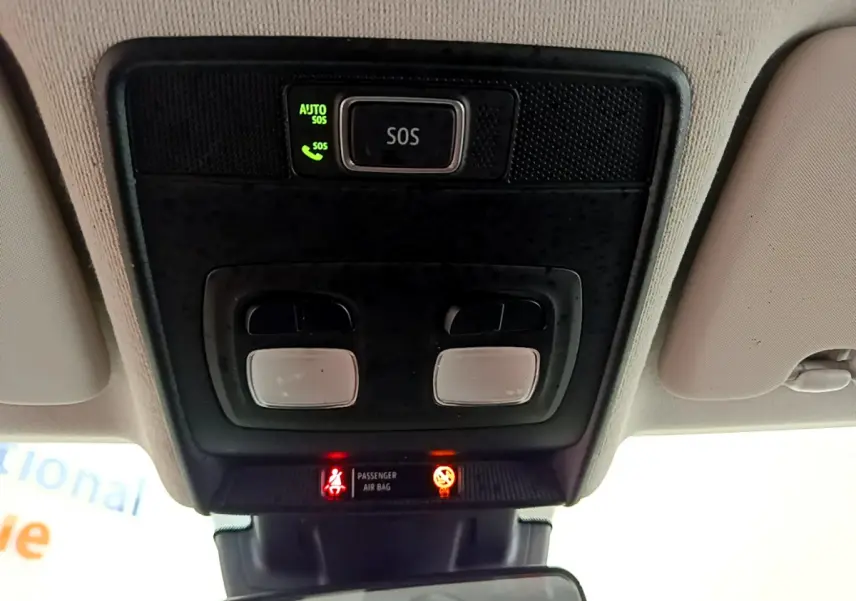 Vue en contre-plongée du plafonnier intérieur de la Renault Clio Business blanc avec bouton SOS et voyants allumés.