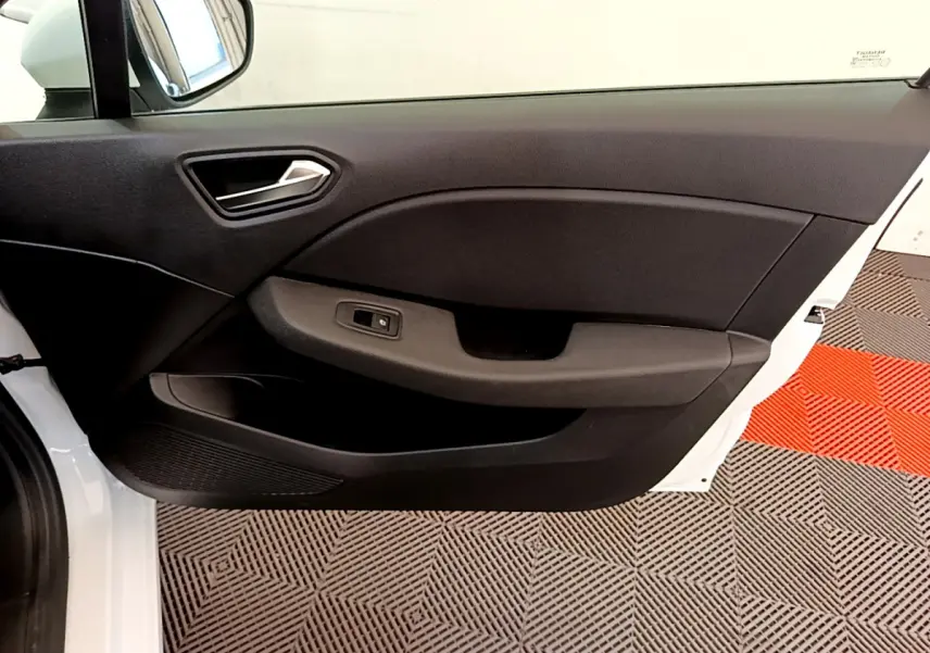 Vue côté gauche de la porte intérieure noire d'une Renault Clio Business blanche, avec poignée et commande de vitre.