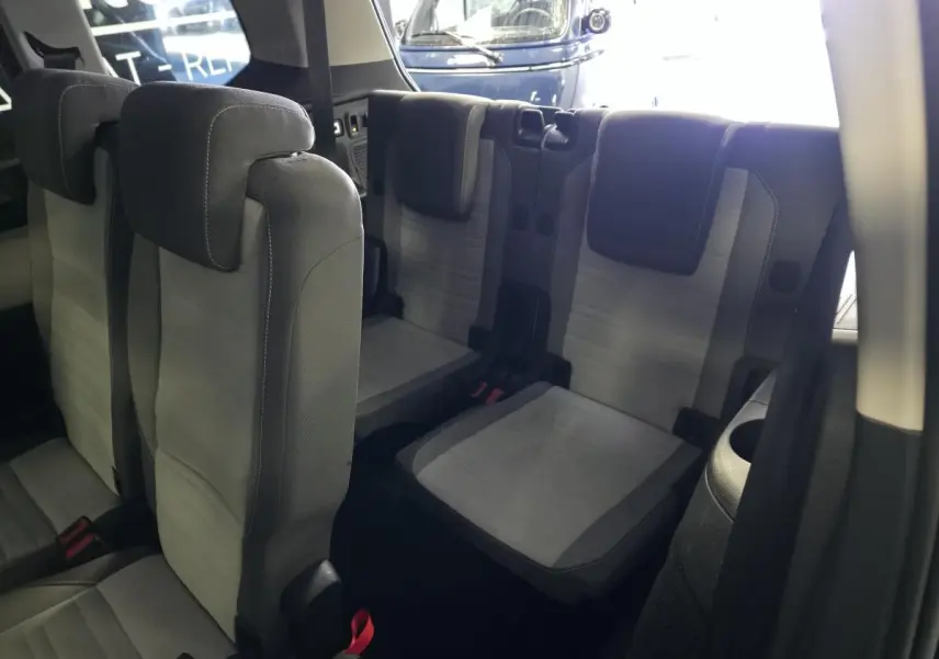 Vue intérieure sur les sièges arrière gris du Volkswagen Touran 2024, montrant la troisième rangée et les appuie-têtes.