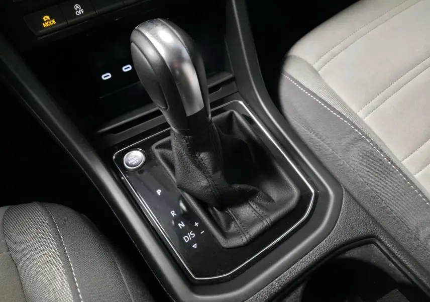 Le levier de vitesse automatique noir et argent du Volkswagen Touran 2024, avec siège gris clair adjacent.